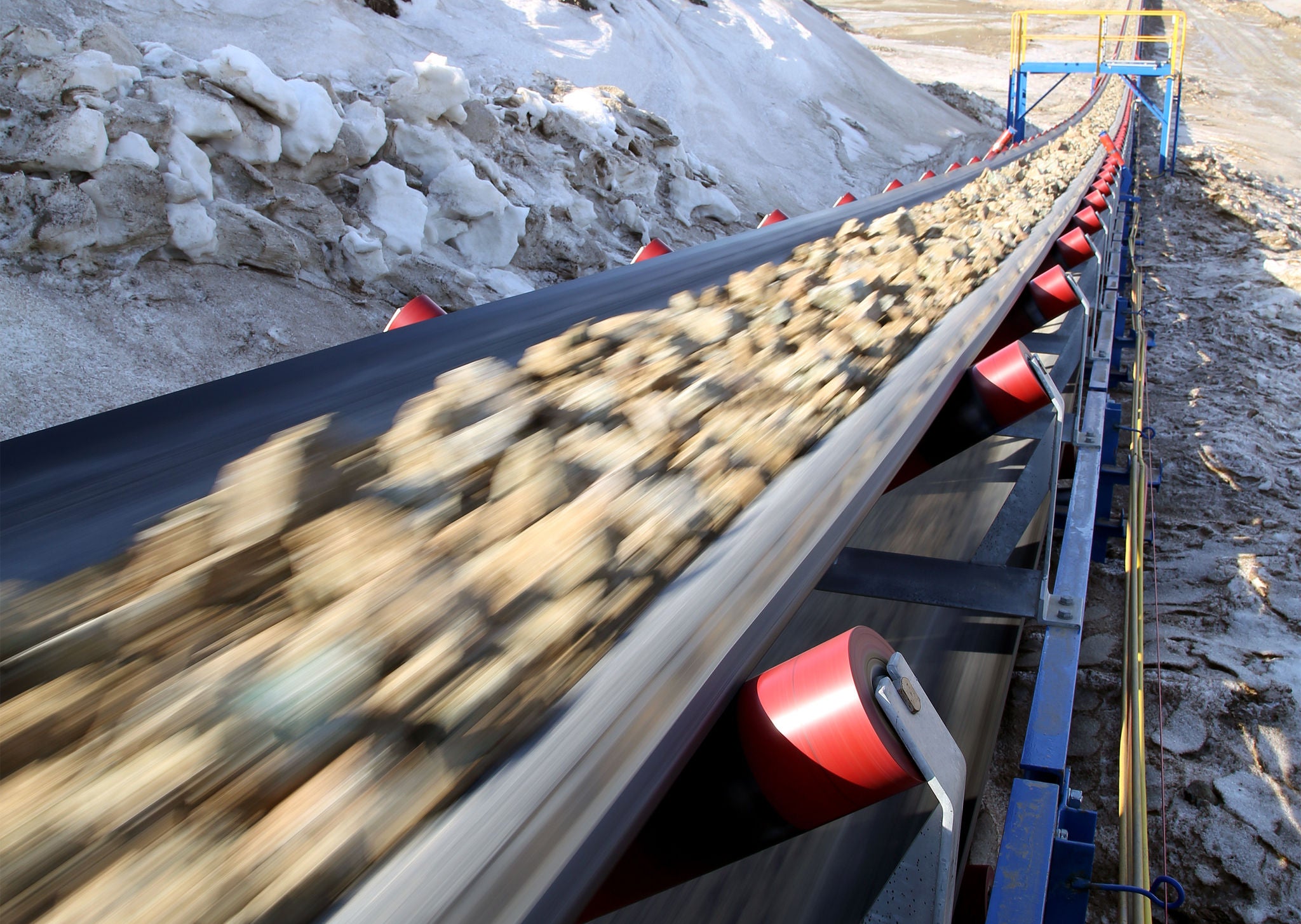 Conveyor belt moves ore from the quarry for processing. Blurred foreground